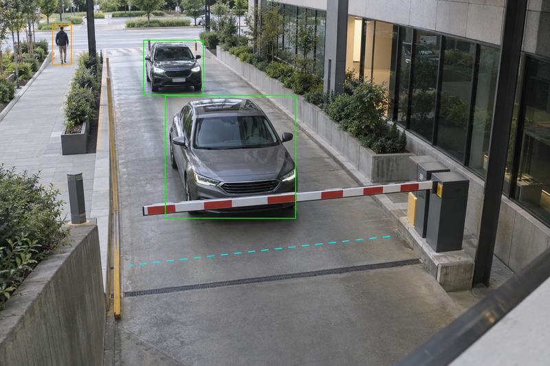 Camera view of a parking entrance with a barrier gate: video analytics outline two vehicles and a distant pedestrian, and a dashed counting line crosses the driveway